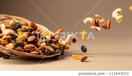 Flying dried fruits and nuts on a beige background. Flying dried fruits and nuts on a beige background. 111643072