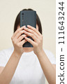 A woman sitting and taking pictures 111643244