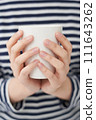 The young woman is holding cup 111643262