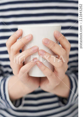 The young woman is holding cup The young woman is holding cup 111643262