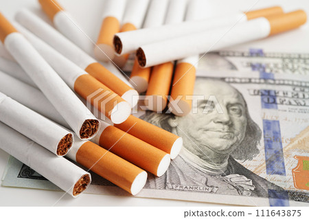 Cigarette on US dollar banknotes, cost, trading, marketing and production, No smoking concept. Cigarette on US dollar banknotes, cost, trading, marketing and production, No smoking concept. 111643875