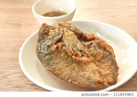 deep fried black-banded trevally fish on plate dipping spicy chili sauce deep fried black-banded trevally fish on plate dipping spicy chili sauce 111643963