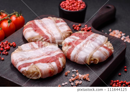 Round minced chicken or pork cutlet wrapped in bacon with salt, spices and herbs Round minced chicken or pork cutlet wrapped in bacon with salt, spices and herbs 111644125