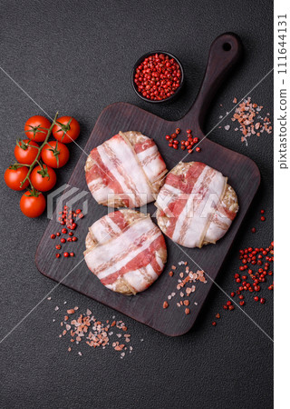 Round minced chicken or pork cutlet wrapped in bacon with salt, spices and herbs 111644131