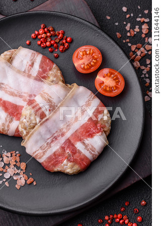 Round minced chicken or pork cutlet wrapped in bacon with salt, spices and herbs 111644146