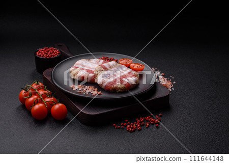 Round minced chicken or pork cutlet wrapped in bacon with salt, spices and herbs 111644148
