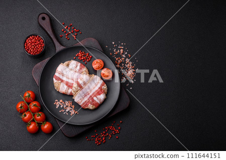 Round minced chicken or pork cutlet wrapped in bacon with salt, spices and herbs 111644151