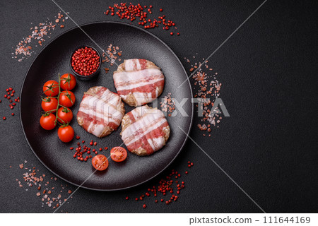 Round minced chicken or pork cutlet wrapped in bacon with salt, spices and herbs 111644169