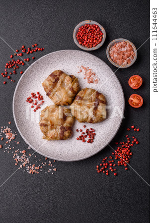 Round minced chicken or pork cutlet wrapped in bacon with salt, spices and herbs Round minced chicken or pork cutlet wrapped in bacon with salt, spices and herbs 111644463