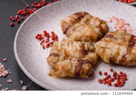 Round minced chicken or pork cutlet wrapped in bacon with salt, spices and herbs 111644464