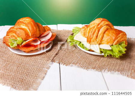 Minimalism, food on a background. Empty text space, mocap. Croissant with cheese sausage greens. 111644505