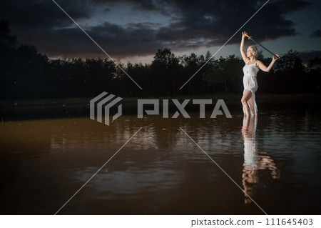 Ethereal Woman Holding sword by Lakeside at Dusk Ethereal Woman Holding sword by Lakeside at Dusk 111645403
