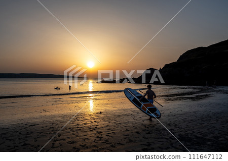 Surfer On Pwllgwaelod Beach And Dinas Head At The Wild Atlantic Coast Of Pembrokeshire In Wales, United Kingdom 111647112