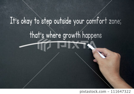 Hand writing It is okay to step outside your comfort zone affirmation on black board Hand writing It is okay to step outside your comfort zone affirmation on black board 111647322