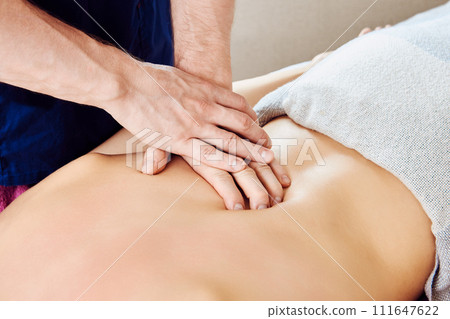 Close-up of massage therapist hands giving deep tissue massage to white woman back. Close-up of massage therapist hands giving deep tissue massage to white woman back. 111647622