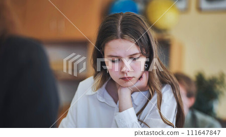 A girl student writes math formulas in a notebook. A girl student writes math formulas in a notebook. 111647847