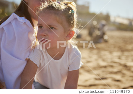 Cute baby girl with her loving mother on the sandy each 111649170