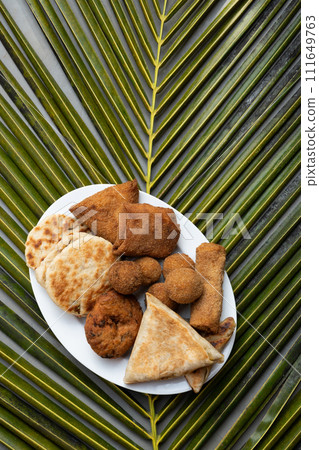 Authentic Sri Lankan different street food, short eats. Vegetable roti, coconut roti, cutlets, mutton rolls on white plate. Snacks made with tuna, potatoes, onion and deep fried. View from above 111649763