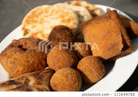 Authentic Sri Lankan different street food, short eats. Vegetable roti, Chinese rolls, coconut roti, cutlets, mutton rolls. Snacks made with tuna, potatoes, onion and deep fried. Close up. 111649788