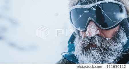 Face of man climber in mask with snow and ice, frozen bearded hiker on storm background. Concept of winter, cold, climbing, people, hike, travel, storm and frost Face of man climber in mask with snow and ice, frozen bearded hiker on storm background. Concept of winter, cold, climbing, people, hike, travel, storm and frost 111650112
