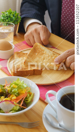 Businessman eating breakfast | Morning set image of coffee, toast, boiled egg, and salad 111652107