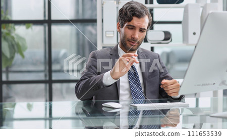 Shocking news. Surprised young man in a suit and tie looking at 111653539