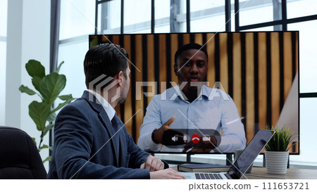 A male businessman is talking to colleagues at an online meeting 111653721