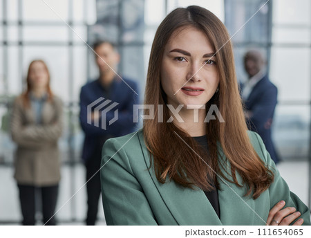 Portrait of a confident young businesswoman standing with her arms crossed in an office 111654065