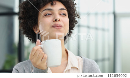Cheerful woman enjoying coffee cup Cheerful woman enjoying coffee cup 111654092