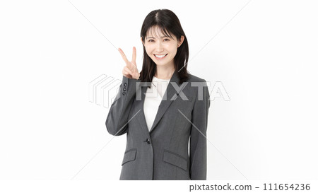 A woman in a suit making a peace sign 111654236
