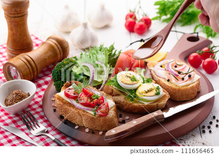 pour olive oil on bruschetta 111656465