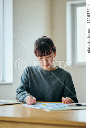 年輕女子在文件上做筆記 111657244