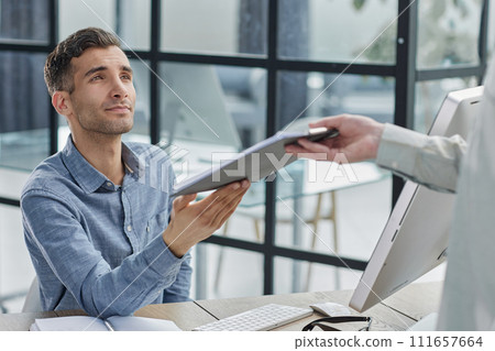 Focus on male hands passing each other folder with papers 111657664