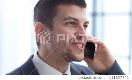 A businessman man in close-up in the office talking on the phone 111657741