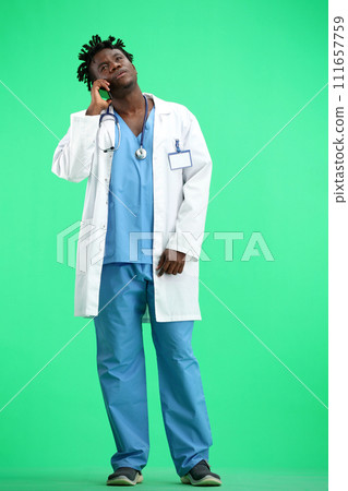 The doctor, in full height, on a green background, talking on the phone The doctor, in full height, on a green background, talking on the phone 111657759