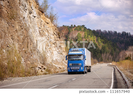 Blue truck on a mountain road in early spring 111657940