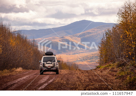 SUV on scenic autumn road in the forest SUV on scenic autumn road in the forest 111657947