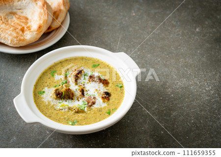 Afghani chicken in green masala curry or Hariyali tikka chicken hara masala with roti or naan bread 111659355
