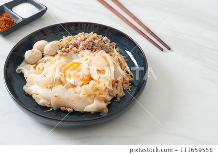 dried spicy noodles with minced pork, meatballs and egg 111659558
