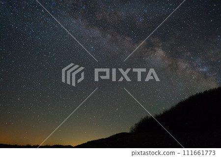 Milky way galaxy and a piece of hill with trees 111661773