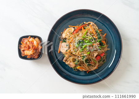 japchae or stir-fried Korean vermicelli noodles with vegetables and pork topped with white sesame 111661990