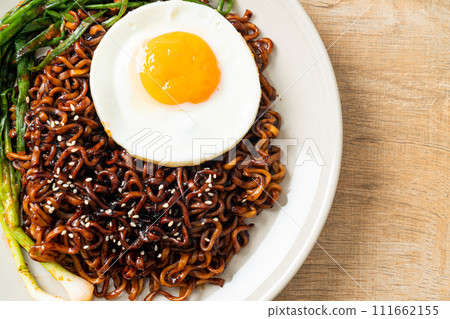 dried Korean spicy black sauce instant noodles with fried egg and kimchi 111662155