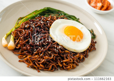 dried Korean spicy black sauce instant noodles with fried egg and kimchi dried Korean spicy black sauce instant noodles with fried egg and kimchi 111662163