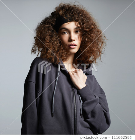 beautiful young woman in hoodie. pretty curly hairstyle girl beautiful young woman in hoodie. pretty curly hairstyle girl 111662595