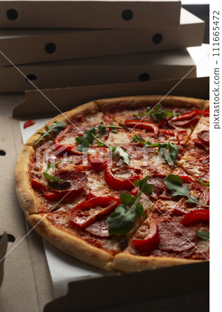 Large Pizza in open carton box on kitchen table closeup view Large Pizza in open carton box on kitchen table closeup view 111665472