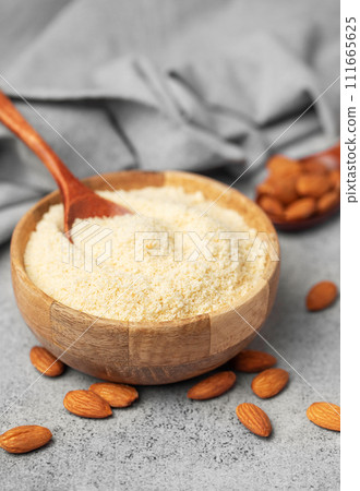 Fresh almond flour in a bowl and almonds Fresh almond flour in a bowl and almonds 111665625