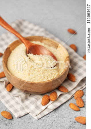 Fresh almond flour in a bowl and almonds Fresh almond flour in a bowl and almonds 111665627
