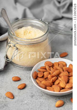 Fresh almond flour in a glass jar and almonds Fresh almond flour in a glass jar and almonds 111665628