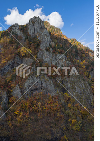 Japan: Valley, Senjo Rock, and autumn leaves visible from the observation deck of Hoheikyo Dam in Jozankei, Minami Ward, Sapporo City, Hokkaido 111667716