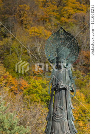 Yumeden Kanzeon Bodhisattva statue and autumn leaves at Kamuikotan in Asahikawa City, Hokkaido, Japan 111668252